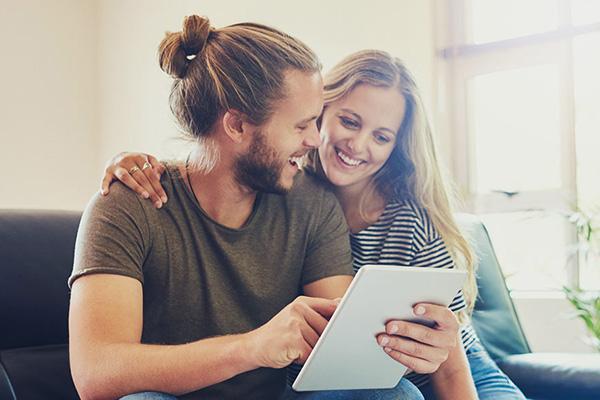 军事 student and spouse smile together as they browse options on a tablet